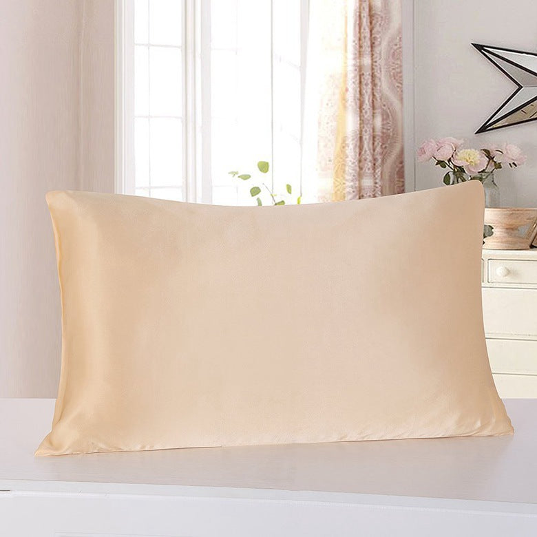 Taie d'oreiller Nacre en satin champagne sur un oreiller, dans une chambre