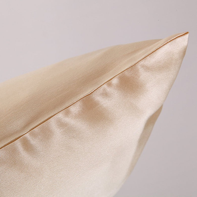 Gros plan sur le reflet du satin champagne de la taie Nacre
